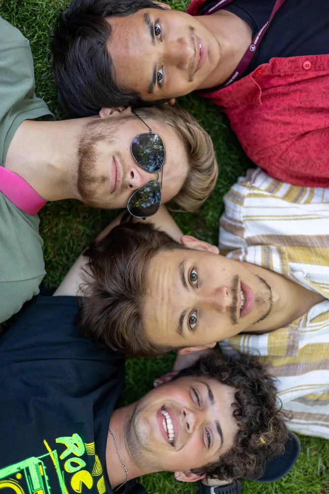 Four friends lying together with their heads toward the camera