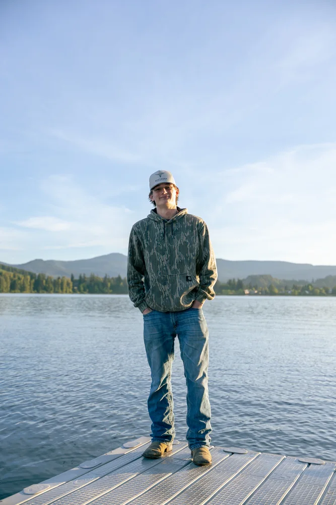 Full-length portrait on a dock with mountains behind