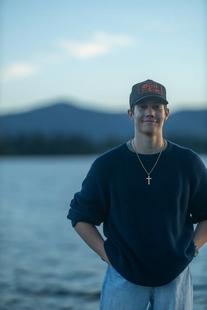 Portrait in a cap beside a lake at dusk