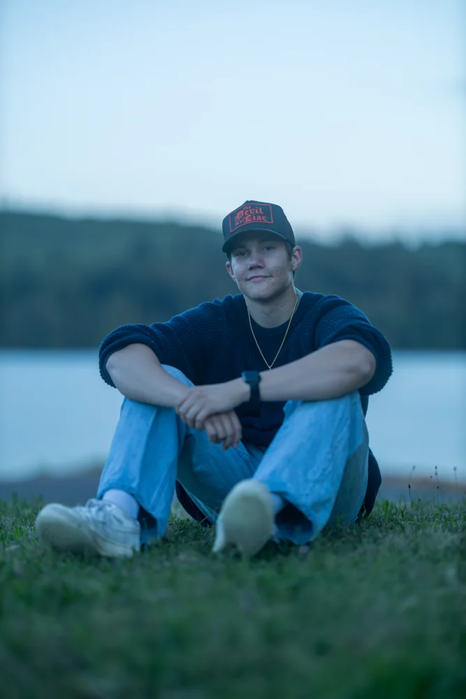 Seated portrait on a grassy lakeshore