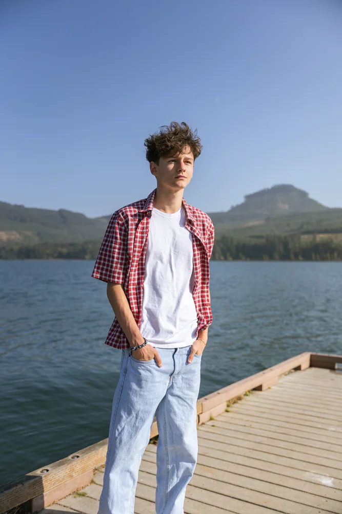 Portrait on a sunlit dock with mountains across the lake