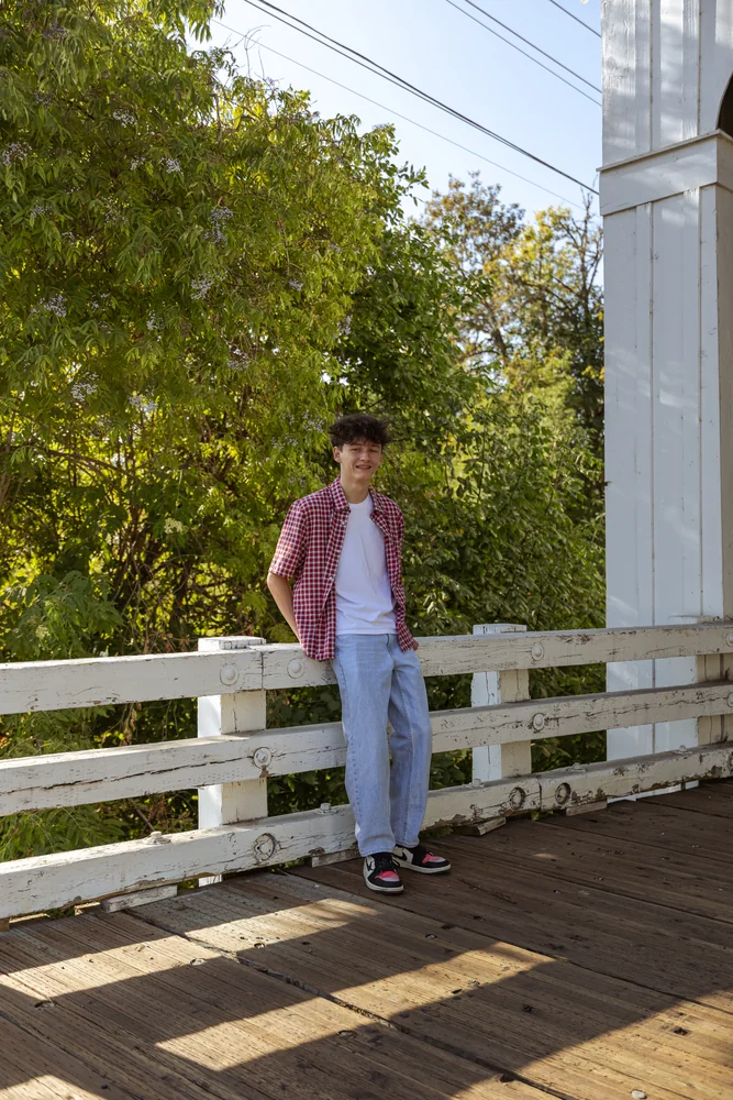 Portrait beside the white railing of a bridge