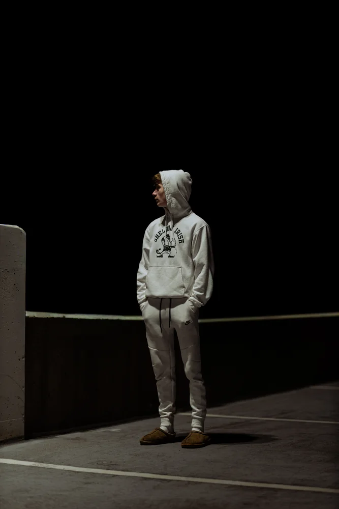 Full-length portrait beside a railing at night