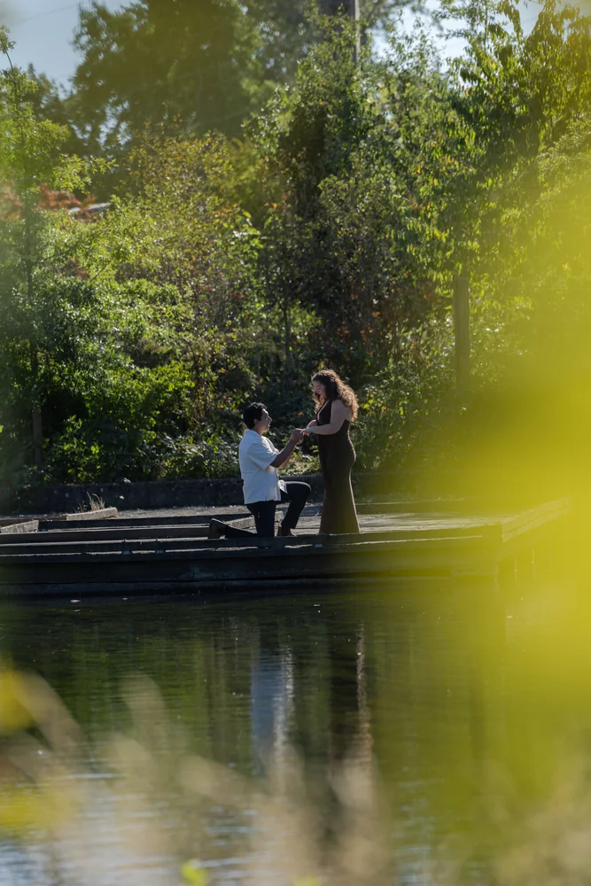 A proposal on a wooden dock surrounded by trees