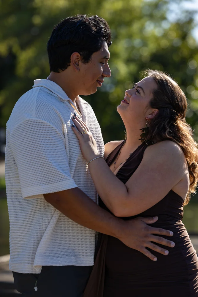 A newly engaged couple embracing beside the water