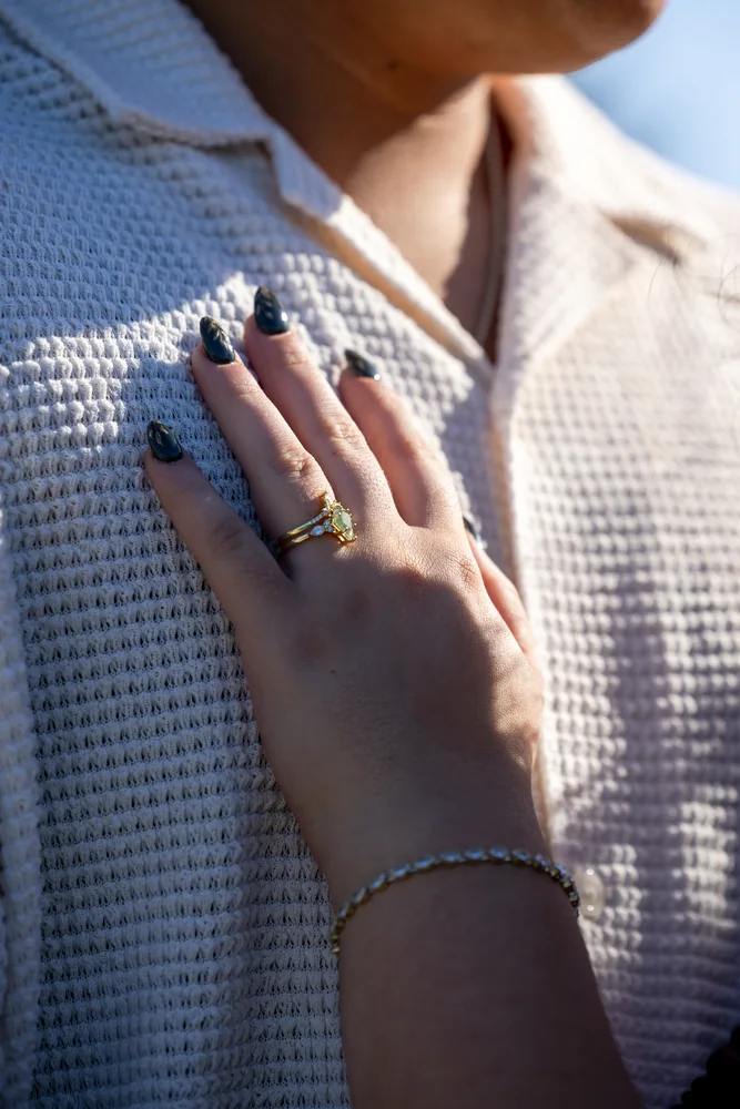 Close-up of an engagement ring resting against a partner's chest