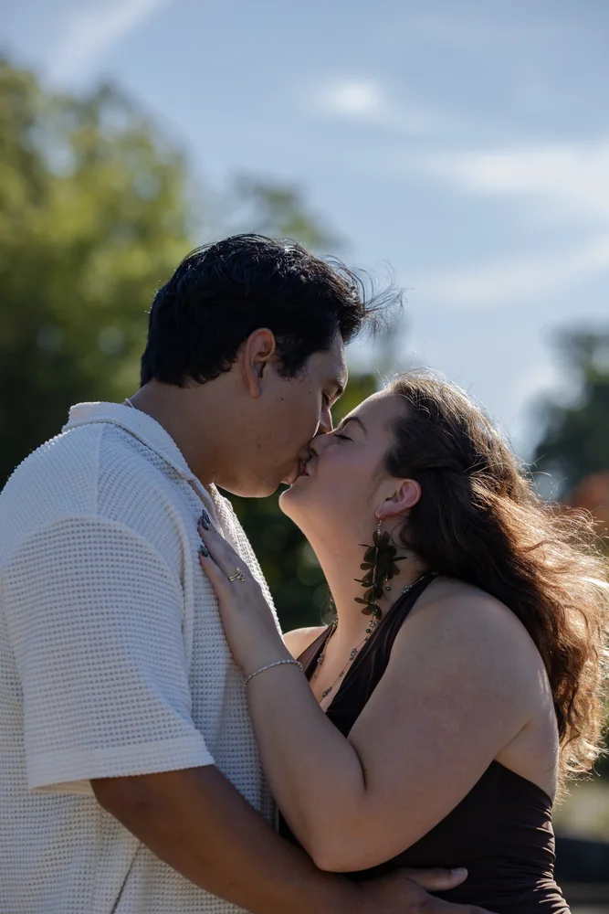 A newly engaged couple sharing a kiss