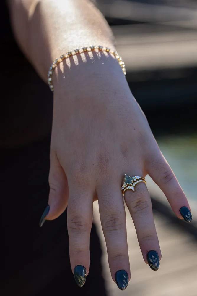 Close-up of the engagement ring and painted fingernails