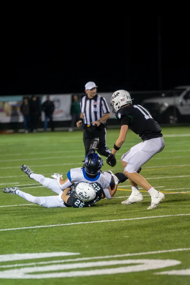 Football action on the turf under stadium lights