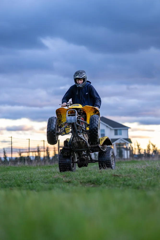 Motocross rider seen head-on beneath a cloudy sky