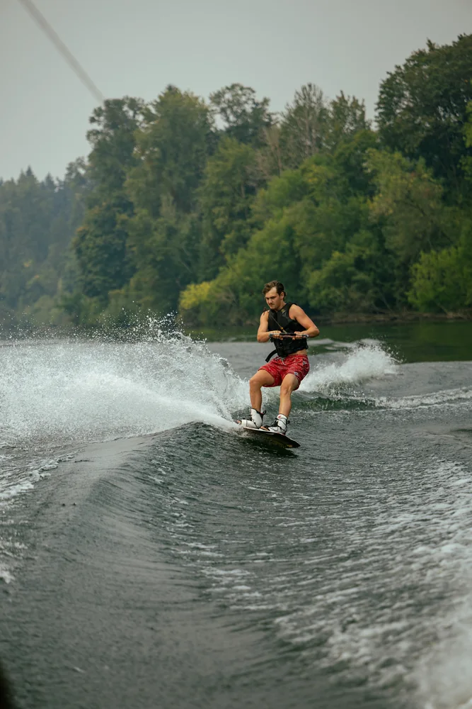 Wakeboarder riding the wake in sunlight