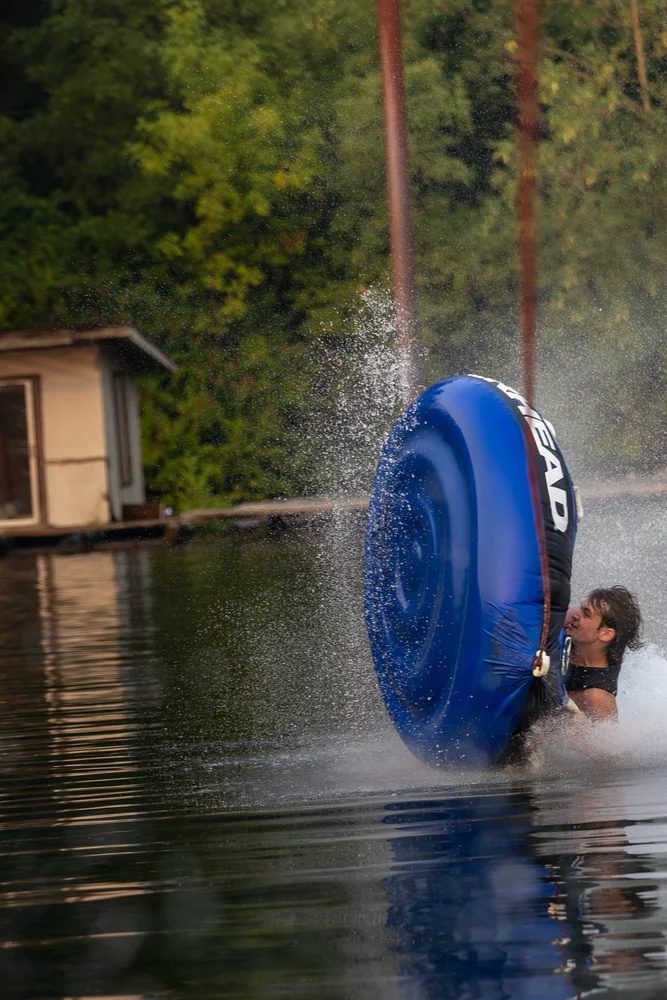 A blue inflatable tube tipping upright on the water