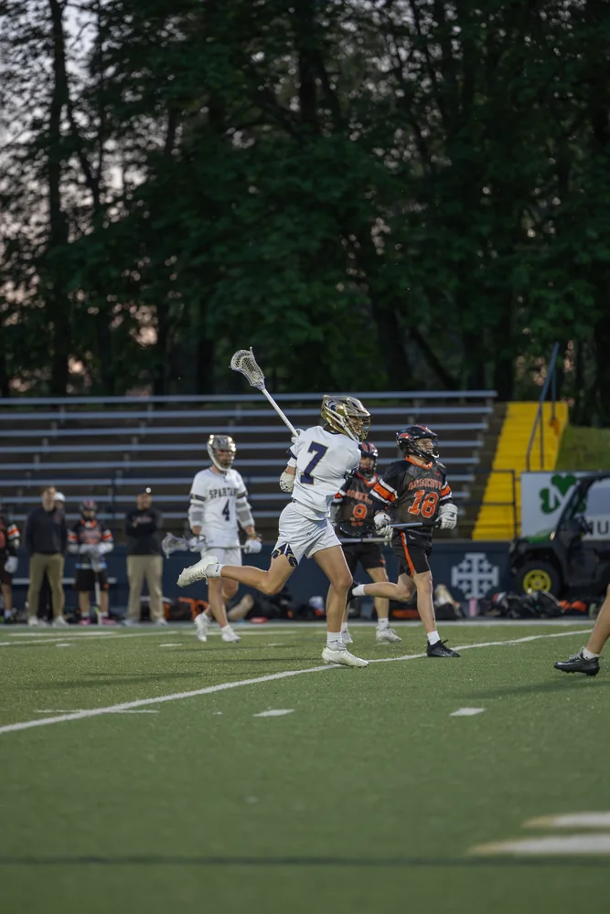 Lacrosse players reaching their sticks into the air