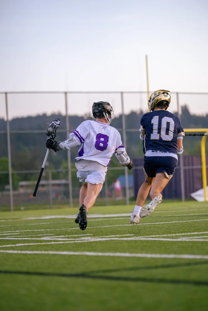 Lacrosse players racing across the field