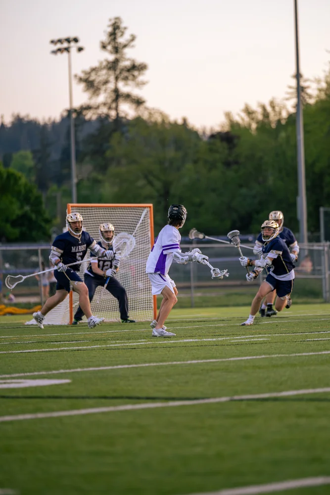 Lacrosse players moving toward the goal
