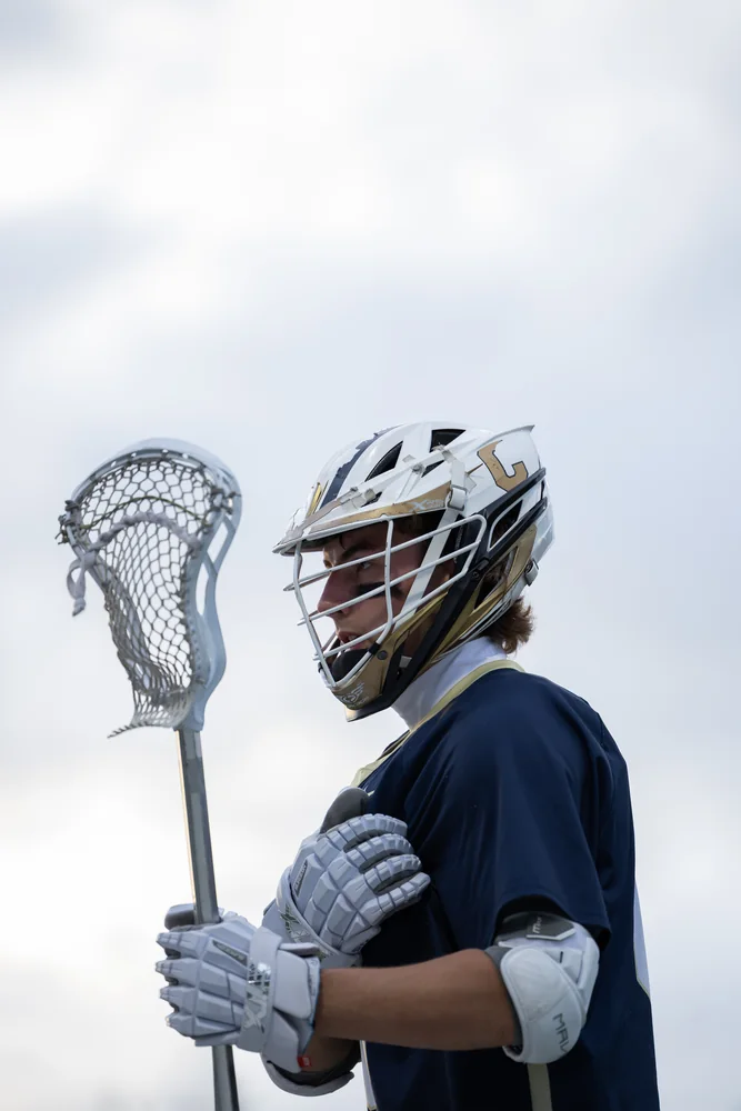 Lacrosse player holding a stick, photographed in profile