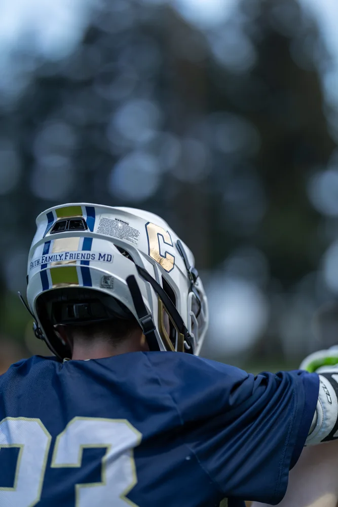 Close-up of a lacrosse player's helmet and jersey from behind